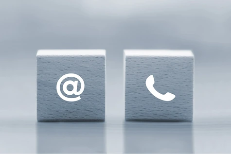 Holzwürfel mit einem @-Symbol und einem Telefon-Symbol