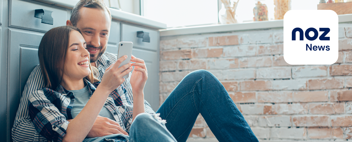 Paar schaut auf Smartphone mit News App